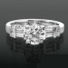Tiffany Style Engagement Ring with Tapered Baguette and Small Round Side Accent Diamonds surrounded by beveled raised ribbon ridges Laying